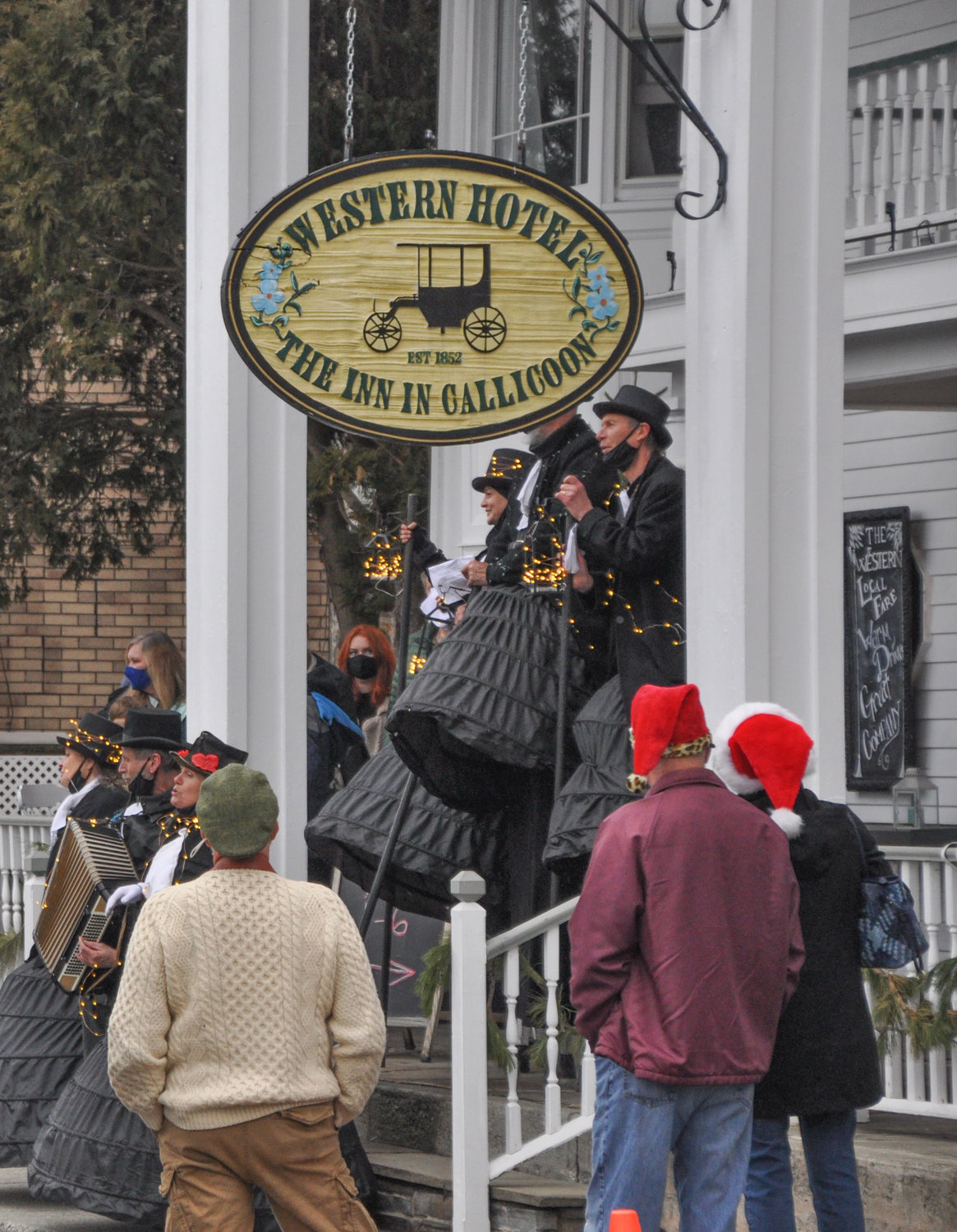The Farm Arts Collective lightened up considerably while caroling on the steps of the historic Western Hotel.
